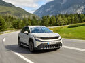 Skoda Epiq in der Fahrt auf einer kurvigen Bergstraße zwischen Wald und Wiesen in den Alpen.