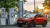 Subaru Uncharted 77 FWD Active in Orange beim Laden an einer Schnellladesäule von Shell Recharge.