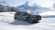 Suzuki Across SUV fährt auf verschneiter Straße in alpiner Landschaft, Seitenansicht mit Allradantrieb im Wintereinsatz.