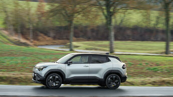 Suzuki e-Vitara in der Seitenansicht während der Fahrt auf einer Landstraße