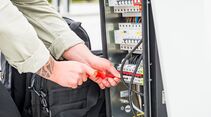 Techniker arbeitet an der elektrischen Installation einer Ladestation