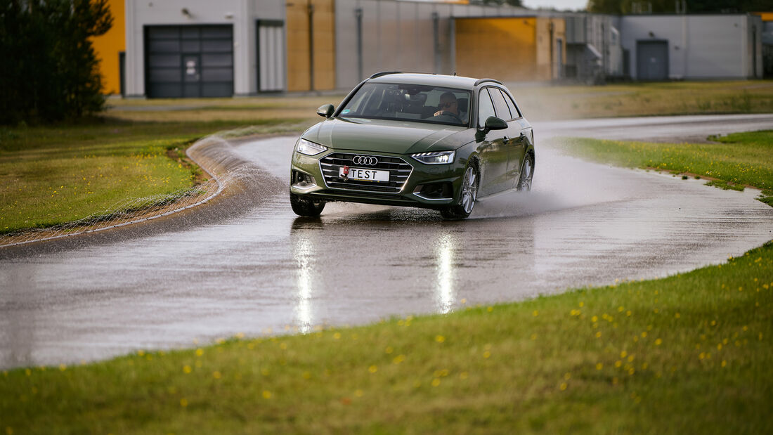 Testfahrzeug fährt im ADAC-Sommerreifentest auf nasser Fahrbahn durch eine Kurve zur Bewertung von Handling und Haftung.