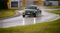 Testfahrzeug fährt im ADAC-Sommerreifentest auf nasser Fahrbahn durch eine Kurve zur Bewertung von Handling und Haftung.