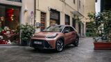 Toyota Aygo X Hybrid fährt durch eine enge Altstadtstraße.