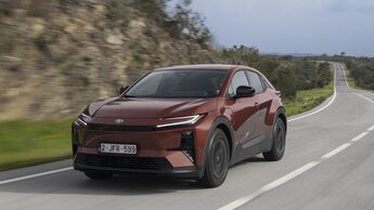 Toyota C-HR+ in Frontansicht auf kurviger Landstraße während der Fahrt