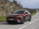 Toyota C-HR+ in Frontansicht auf kurviger Landstraße während der Fahrt