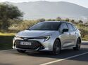 Toyota Corolla Touring Sports 2.0 Hybrid in Silber während der Fahrt, Frontansicht auf einer Landstraße.