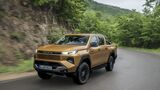 Toyota Hilux auf nasser Straße während der Fahrt in Frontansicht.