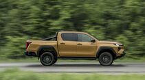 Toyota Hilux in Seitenansicht während der Fahrt auf einer Straße.