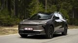 Toyota bZ4X Touring AWD auf einer kurvigen Straße vor Wald- und Bergkulisse