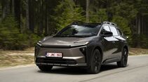 Toyota bZ4X Touring AWD auf einer kurvigen Straße vor Wald- und Bergkulisse