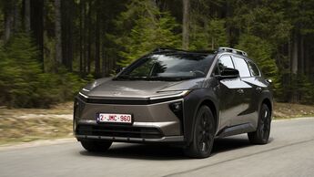 Toyota bZ4X Touring AWD auf einer kurvigen Straße vor Wald- und Bergkulisse