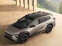 Toyota bZ4X Touring als Elektro-SUV in schräger Draufsicht, mit schwarzem Dach, Dachreling und schwarzer Leichtmetallfelge in moderner Architektur