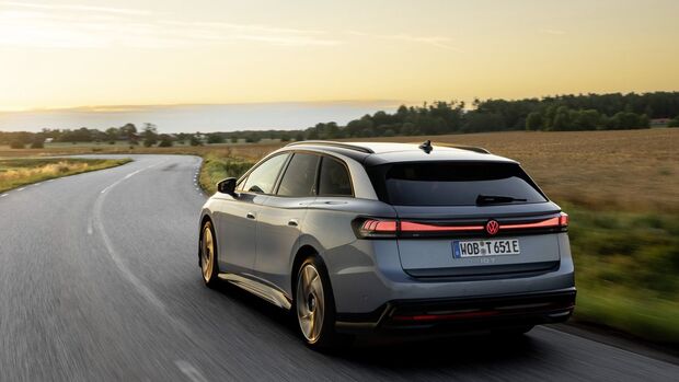 VW ID.7 Tourer von hinten während der Fahrt auf einer Landstraße.