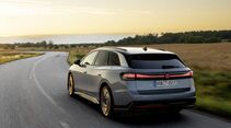 VW ID.7 Tourer von hinten während der Fahrt auf einer Landstraße.