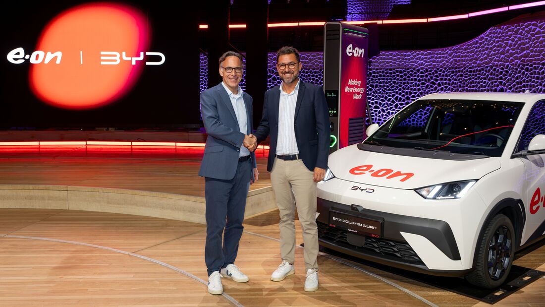 Vertreter von E.ON und BYD besiegeln die Partnerschaft vor einem BYD Dolphin Surf an einer E.ON-Ladesäule.
