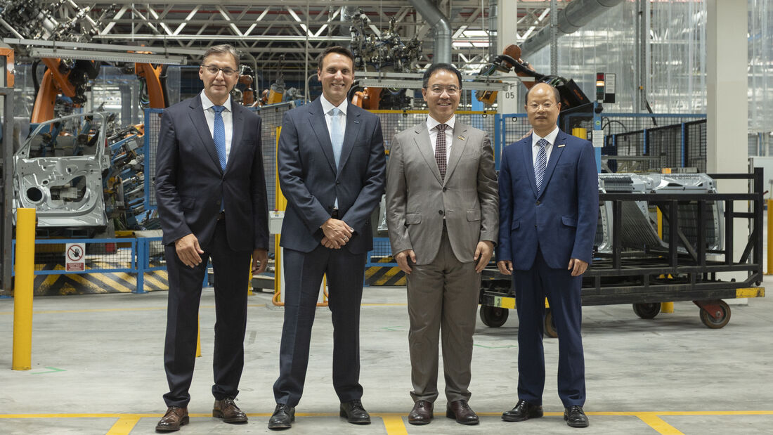 Vertreter von Ford und Geely im Ford-Werk Valencia vor einer automatisierten Produktionsanlage.