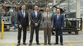 Vertreter von Ford und Geely im Ford-Werk Valencia vor einer automatisierten Produktionsanlage.