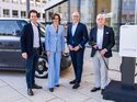 Vier Personen stehen vor einem VW ID. Buzz und einer Ladesaeule bei einem Termin zum Thema bidirektionales Laden.