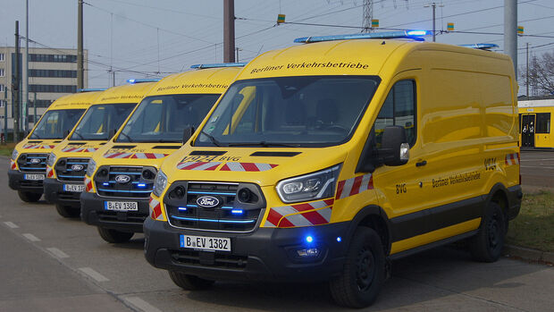Vier gelbe Ford E-Transit der BVG stehen mit eingeschaltetem Blaulicht hintereinander auf einem Betriebshof.