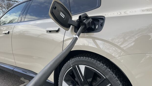 Volvo ES90 beim Laden an einer öffentlichen Ladesäule mit angeschlossenem Ladekabel