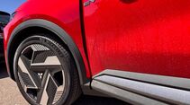 Vorderrad und Seitenpartie des roten Mitsubishi Eclipse Cross mit EV-Emblem.