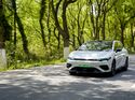 Weisser Leapmotor B05 Elektro-SUV auf Strasse in Frontansicht zwischen Baeumen