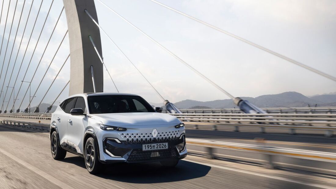 Weißer Renault Filante SUV fährt auf Brücke vor Skyline bei Sonnenaufgang