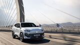 Weißer Renault Filante SUV fährt auf Brücke vor Skyline bei Sonnenaufgang