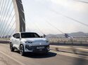 Weißer Renault Filante SUV fährt auf Brücke vor Skyline bei Sonnenaufgang