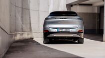 XPENG G6 RWD Long Range in Silber in Heckansicht vor moderner Betonarchitektur.
