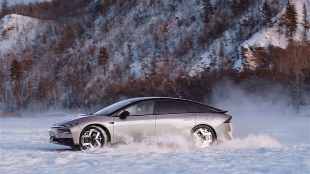 Xpeng P7+ in Seitenansicht bei Fahrt auf verschneiter Strecke mit Schneefahne