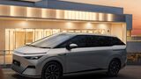 Xpeng X9 als Elektro-Van vor einem modernen Gebäude, Seitenansicht bei Dämmerung.