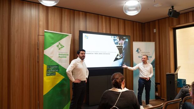 Yannick-Niklas Lober und Javier Seeling von der DAT präsentieren auf der Nakobemo einen Vortrag zu Connected Cars vor Teilnehmenden.