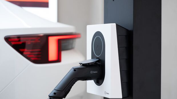 Zaptec-Wallbox mit angeschlossenem Ladekabel vor dem Heck eines Polestar Elektroautos.

