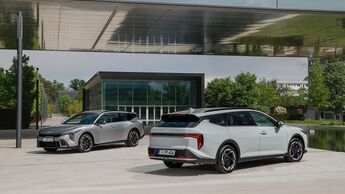 Zwei Kia K4 Sportswagon Modelle vor moderner Gebäudearchitektur.