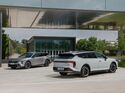 Zwei Kia K4 Sportswagon Modelle vor moderner Gebäudearchitektur.