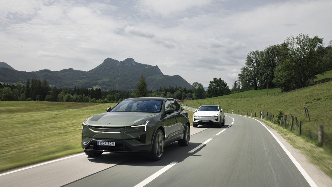 Zwei Polestar 3 Performance fahren auf einer Landstraße durch eine hügelige Landschaft.