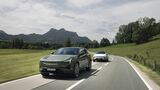 Zwei Polestar 3 Performance fahren auf einer Landstraße durch eine hügelige Landschaft.