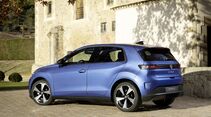 blauer vw id polo in heck-seitenansicht vor steingebaeude auf gepflasterter einfahrt