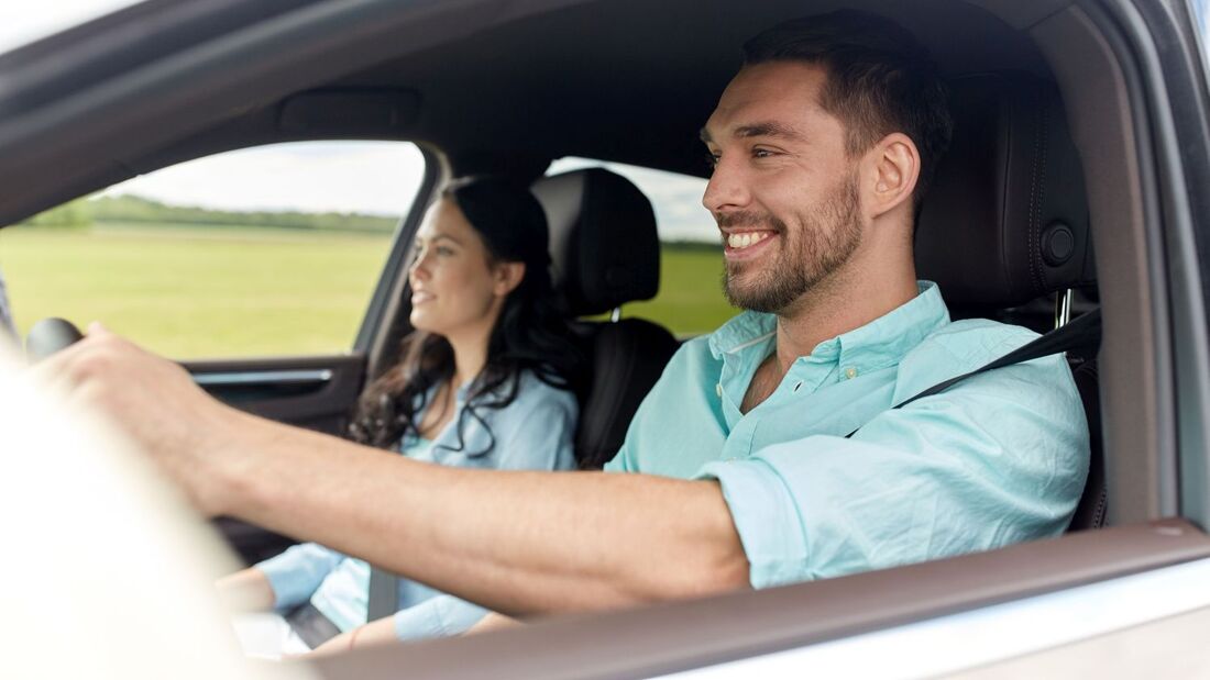 happy man and woman driving in car