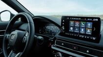 nnenraum des Honda Civic e:HEV mit Lenkrad, digitalem Kombiinstrument und zentralem Infotainment-Display.